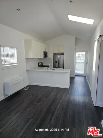 a view of a room with wooden floor and electronic appliances