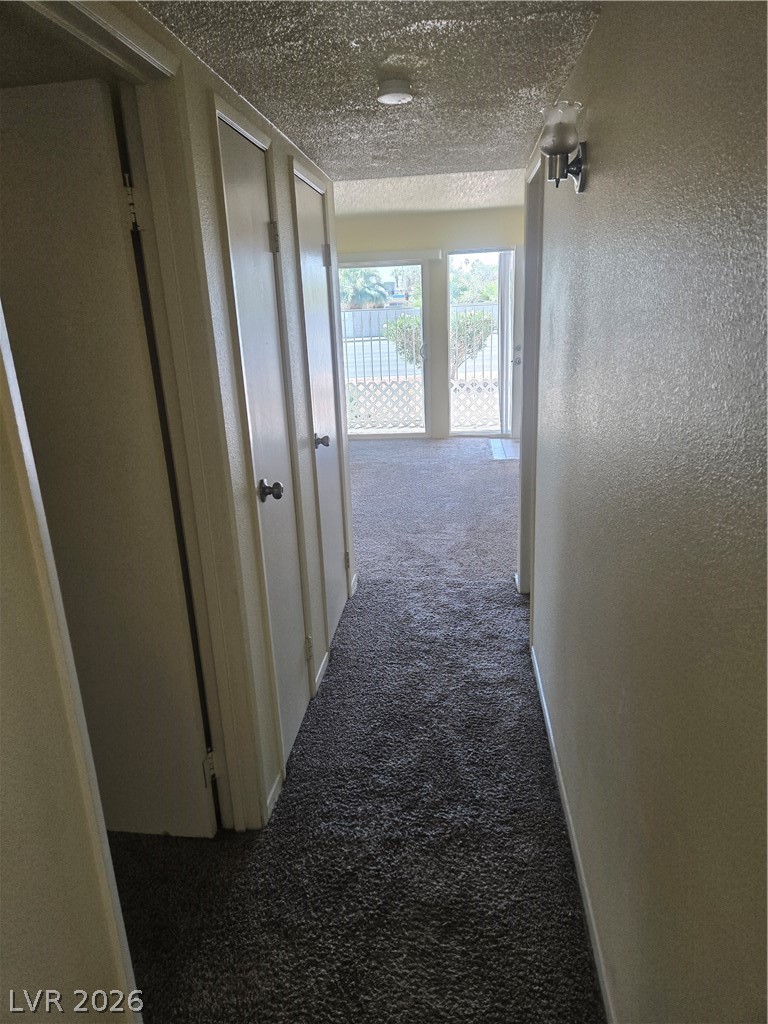 1388 East Desert Inn Road, Unit 2 Las Vegas, NV 89169 - Photo 18 of 23 This interior hallway offers convenient storage with its closet, leading to a sun-filled room at the end.