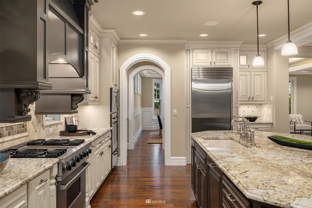 a bedroom with a bed a couch and two large window