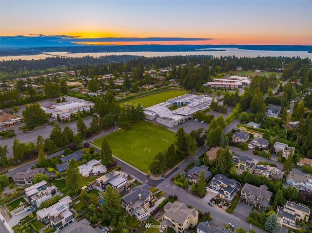 an aerial view of residential houses with outdoor space and ocean view