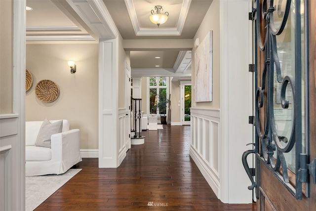a hallway with wooden floor and stairs