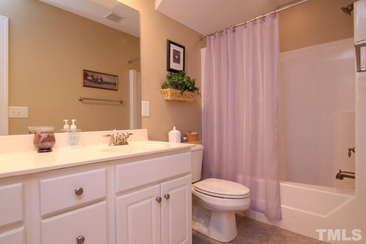 1012 Newburgh Circle Raleigh, NC 27603 - Photo 18 of 25 a bathroom with a toilet a sink a tub and mirror