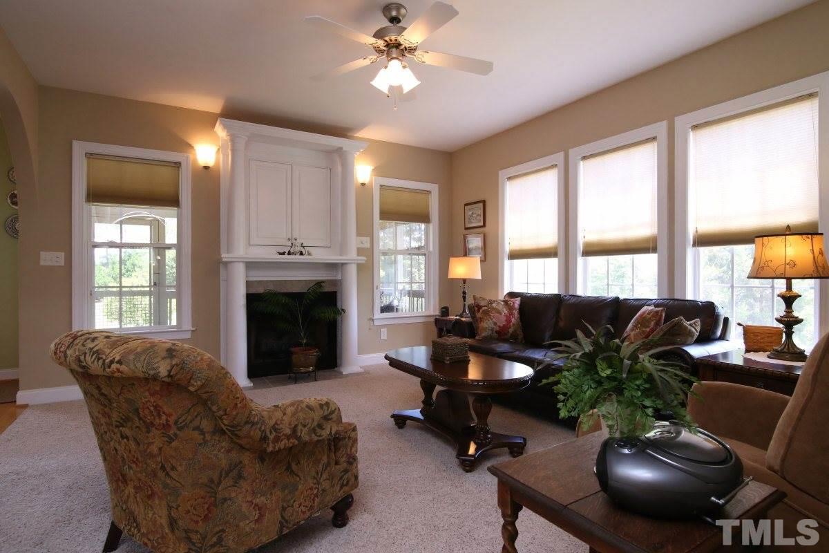 1012 Newburgh Circle Raleigh, NC 27603 - Photo 7 of 25 a living room with furniture a fireplace and a large window