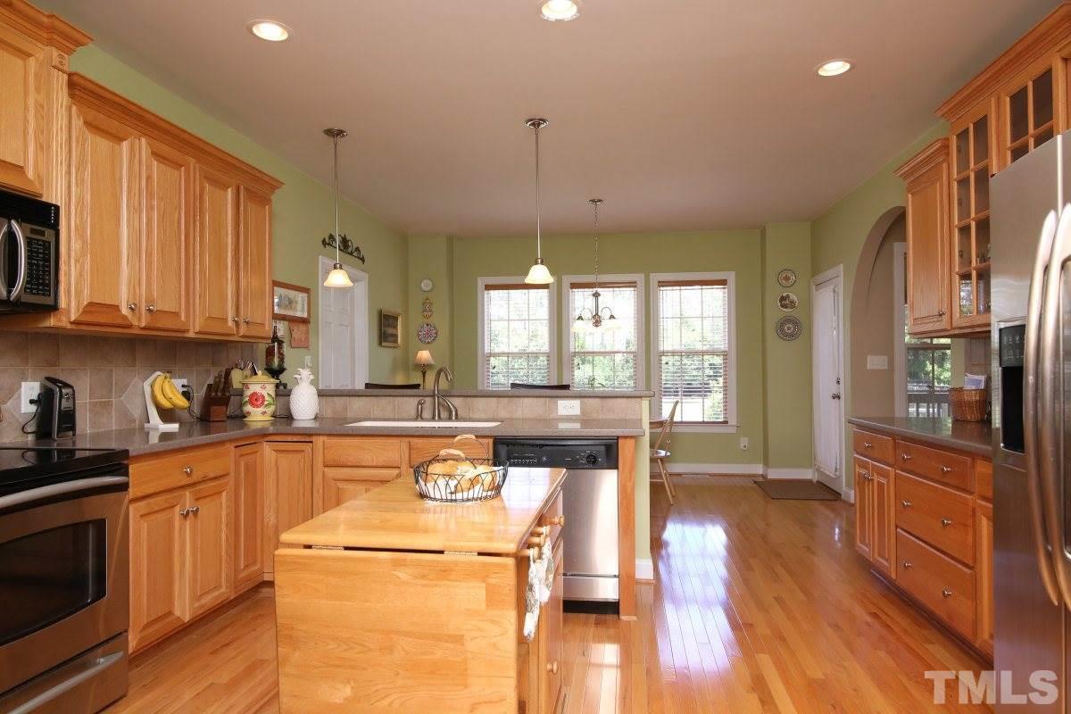 1012 Newburgh Circle Raleigh, NC 27603 - Photo 8 of 25 a kitchen with stainless steel appliances granite countertop a stove a sink dishwasher and a refrigerator with wooden floor