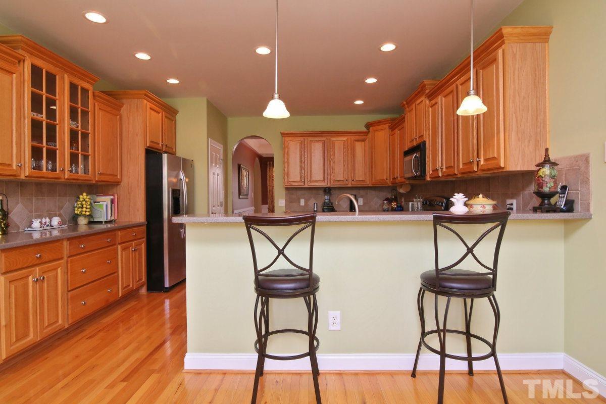1012 Newburgh Circle Raleigh, NC 27603 - Photo 9 of 25 a kitchen with stainless steel appliances kitchen island granite countertop a stove a sink and a refrigerator with wooden floor