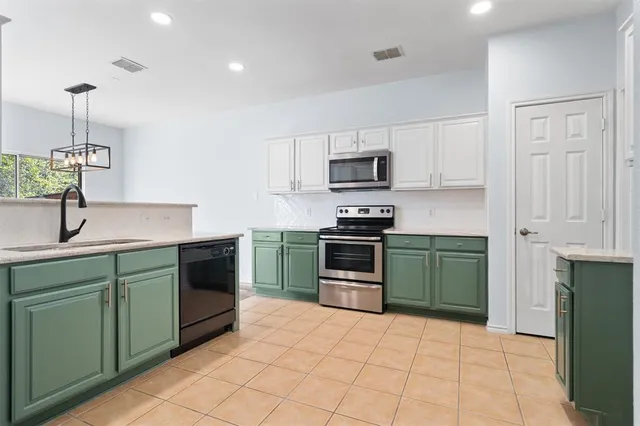 a kitchen with kitchen island a sink stainless steel appliances and cabinets