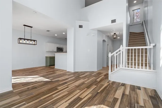 a view of a bedroom with wooden floor & staircase