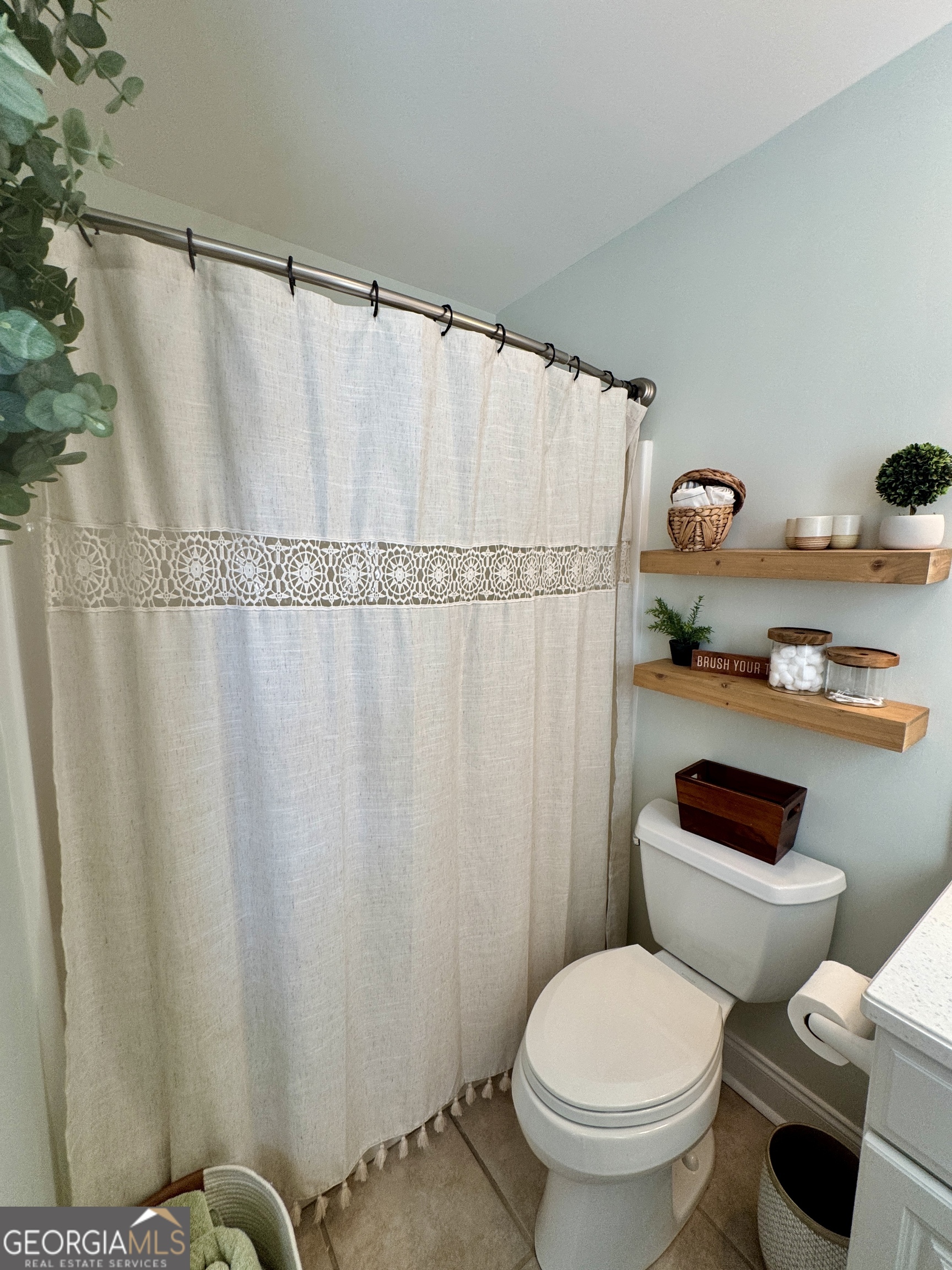 49 Aberdeen Circle Cordele, GA 31015 - Photo 41 of 63 a white toilet sitting next to a shower curtain