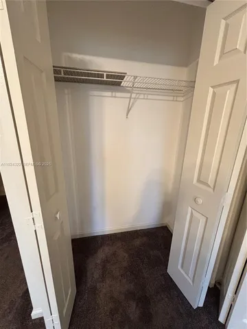 a view of walk in closet with empty racks