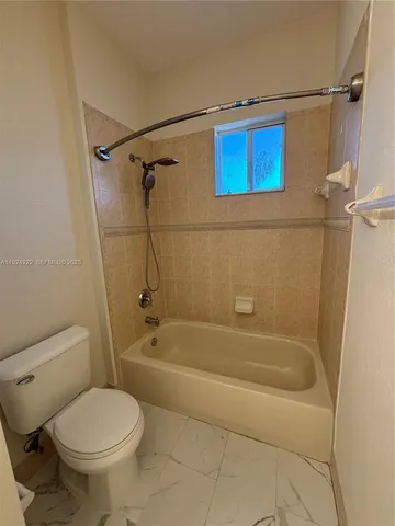 a bath room with a toilet and a bath tub