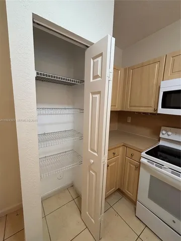 a kitchen with white cabinets and white appliances