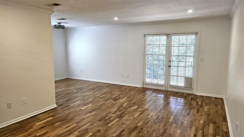 1150 Collier Road Northwest, Unit K12 Atlanta, GA 30318 - Photo 12 of 32 a view of an empty room with a window and wooden floor