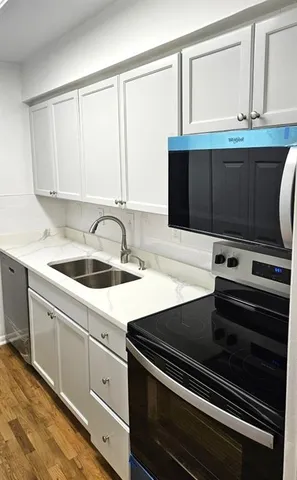 a kitchen with a sink stove and cabinets