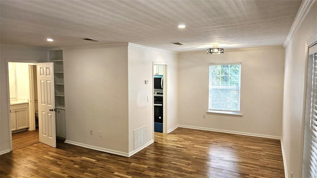 1150 Collier Road Northwest, Unit K12 Atlanta, GA 30318 - Photo 3 of 32 a view of an empty room with wooden floor and a window
