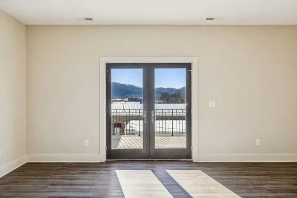 a view of a room with wooden floor and a window