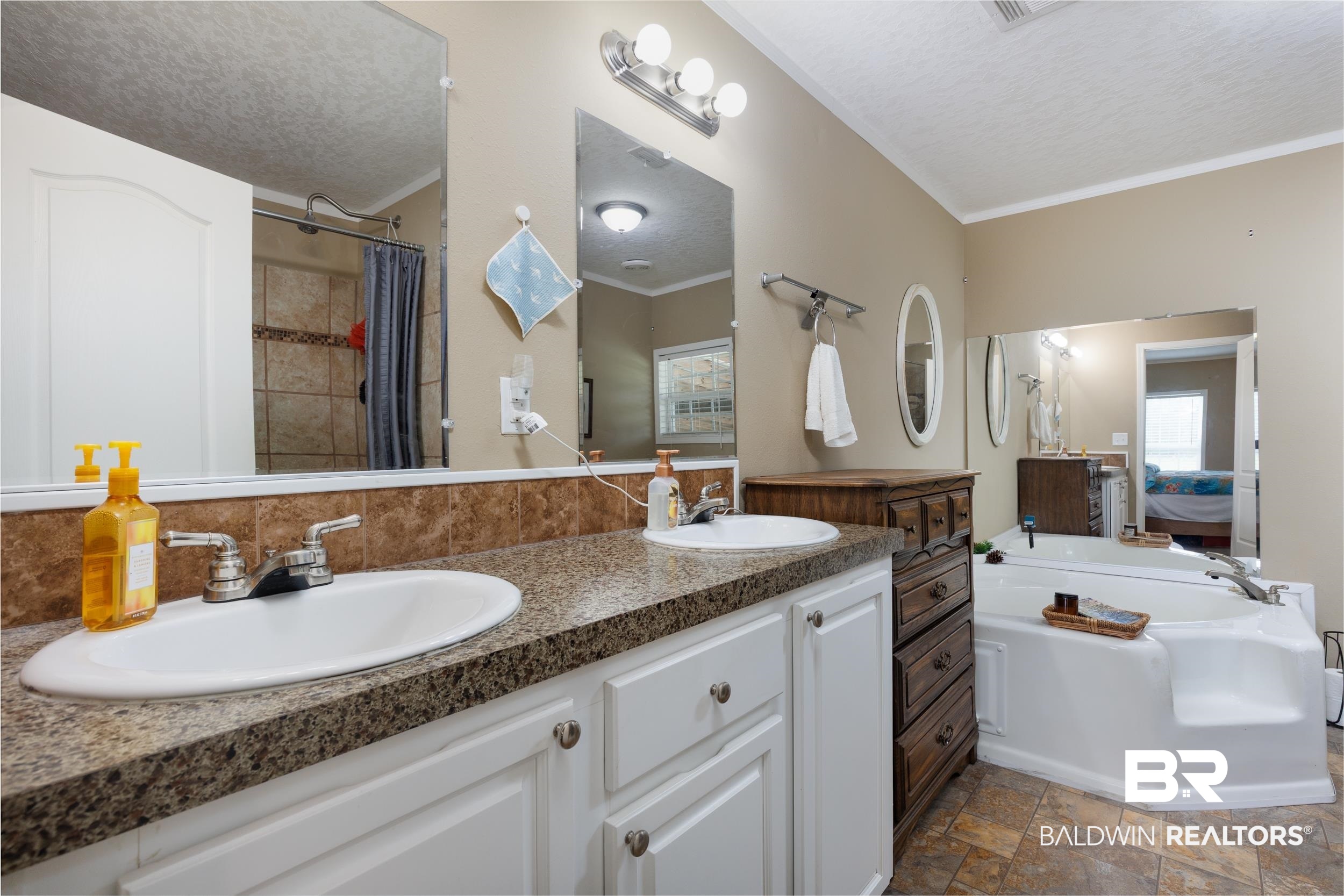 6725 Upper Creek Road Flomaton, AL 36441 - Photo 51 of 61 Bathroom featuring a textured ceiling, stone finish flooring, crown molding, a garden tub, and backsplash
