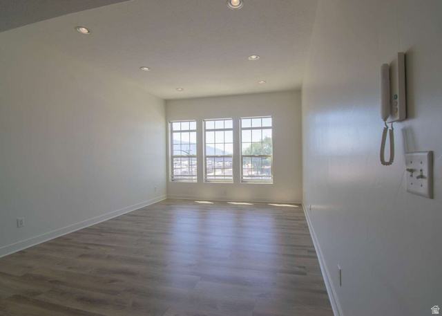 4276 South Main Street, Unit 303 Murray, UT 84107 - Photo 6 of 20 Spacious room featuring wood-finish flooring, recessed ceiling lighting, and multiple windows