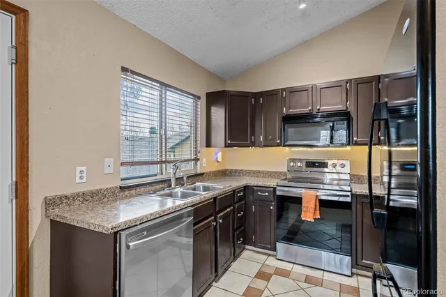 a kitchen with stainless steel appliances granite countertop a sink stove and cabinets