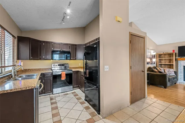 a kitchen with stainless steel appliances granite countertop a refrigerator and a stove