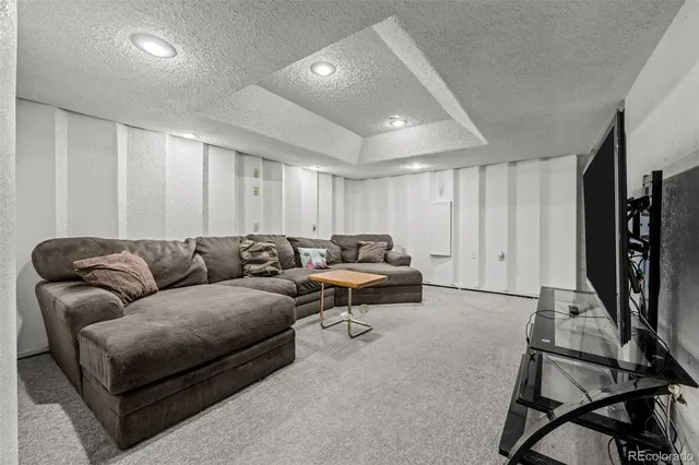 a living room with furniture a flat screen tv and a window