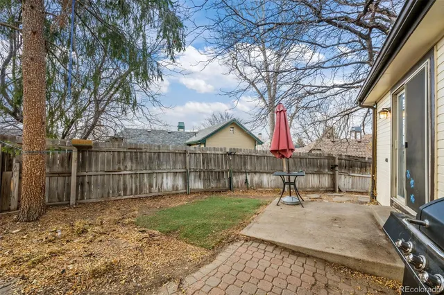 a view of backyard with wooden fence and large trees