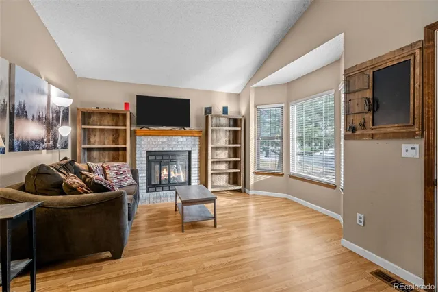 a living room with furniture wooden floor and a fireplace
