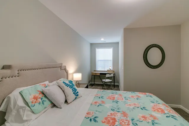 a bedroom with a bed and a lamp