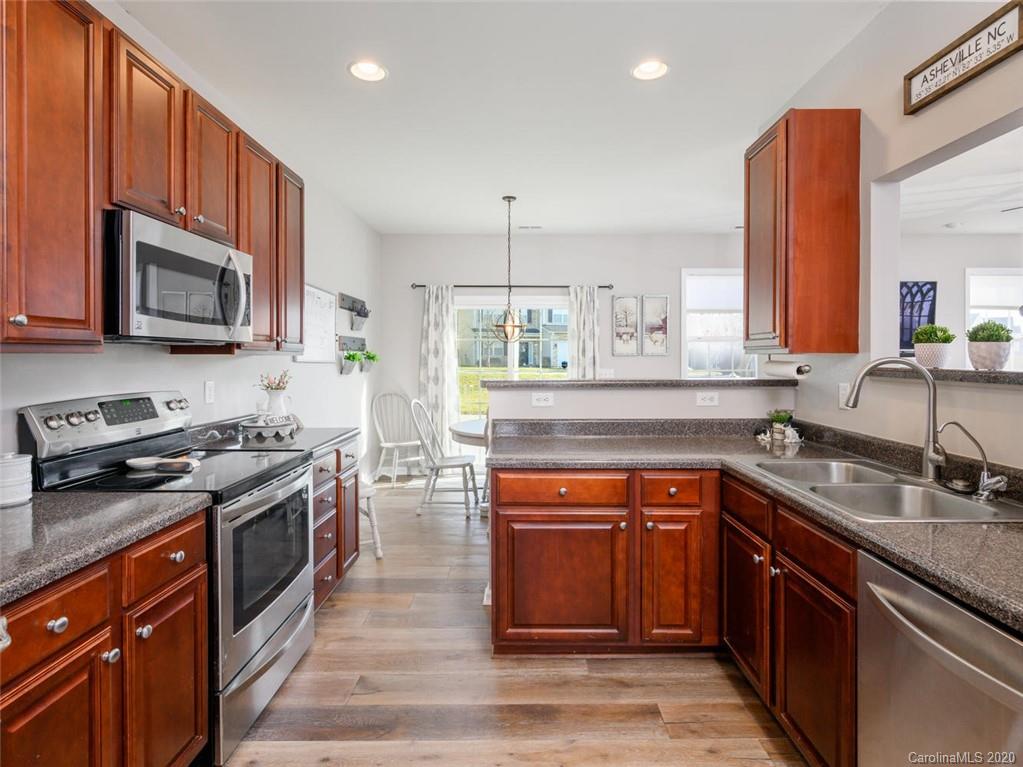 121 Haw River Road Fletcher, NC 28732 - Photo 12 of 42 a kitchen with stainless steel appliances granite countertop a stove top oven a sink dishwasher a microwave oven and a refrigerator