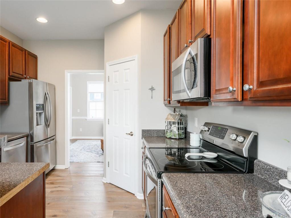 121 Haw River Road Fletcher, NC 28732 - Photo 14 of 42 a kitchen with stainless steel appliances granite countertop a refrigerator a stove and a sink with wooden floor