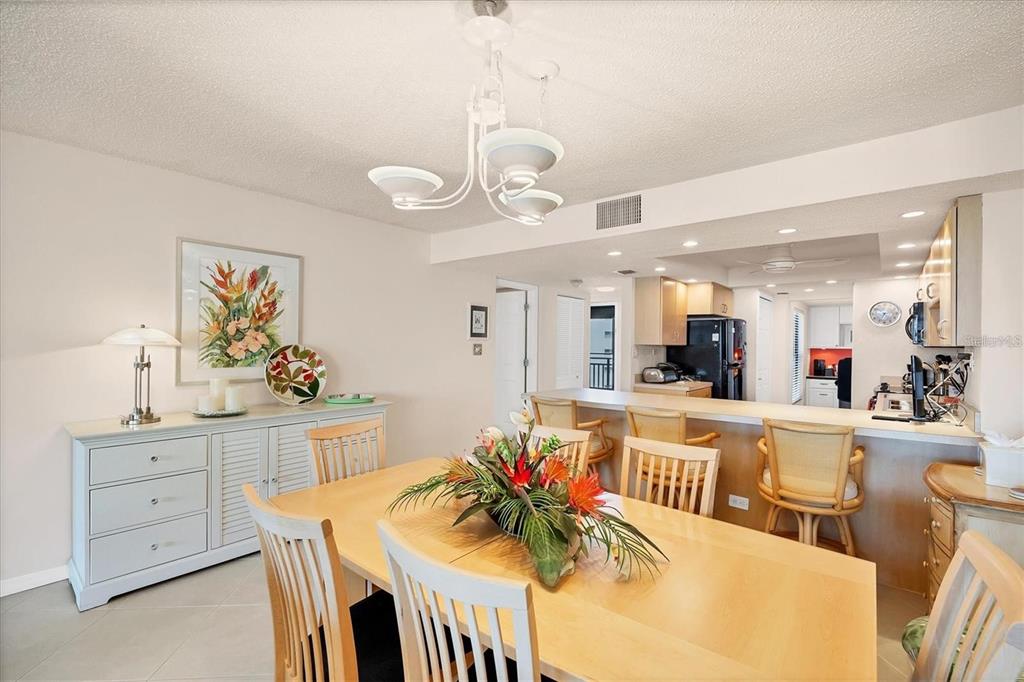 6480 Midnight Pass Road, Unit 506 Sarasota, FL 34242 - Photo 12 of 49 a view of a dining room kitchen and a chandelier