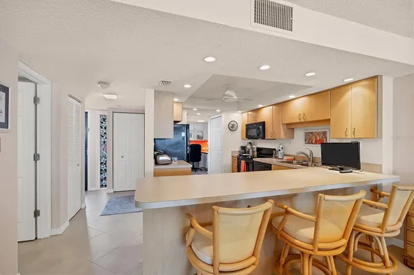 a kitchen with stainless steel appliances granite countertop a refrigerator and a stove top oven