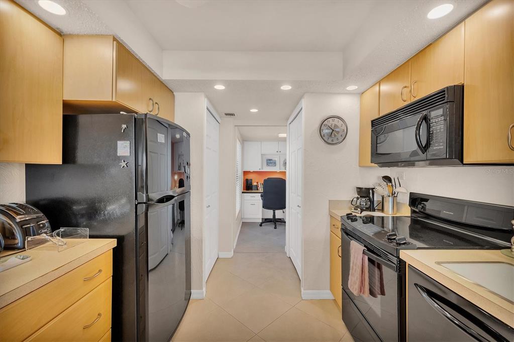 6480 Midnight Pass Road, Unit 506 Sarasota, FL 34242 - Photo 30 of 49 a kitchen with stainless steel appliances granite countertop a refrigerator and a stove top oven