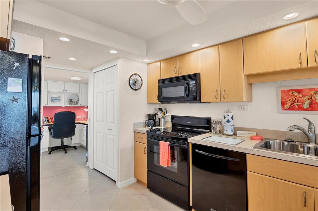 6480 Midnight Pass Road, Unit 506 Sarasota, FL 34242 - Photo 31 of 49 a kitchen with stainless steel appliances granite countertop a stove top oven a sink dishwasher and cabinets with wooden floor