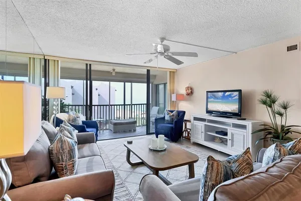 a living room with furniture a flat screen tv and a large window