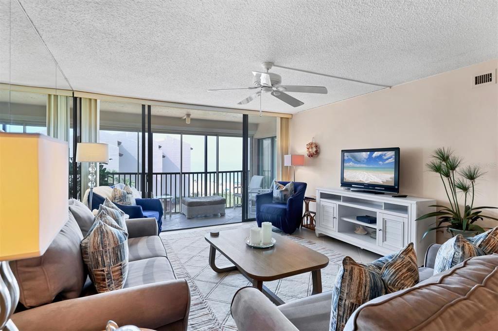 6480 Midnight Pass Road, Unit 506 Sarasota, FL 34242 - Photo 9 of 49 a living room with furniture a flat screen tv and a large window