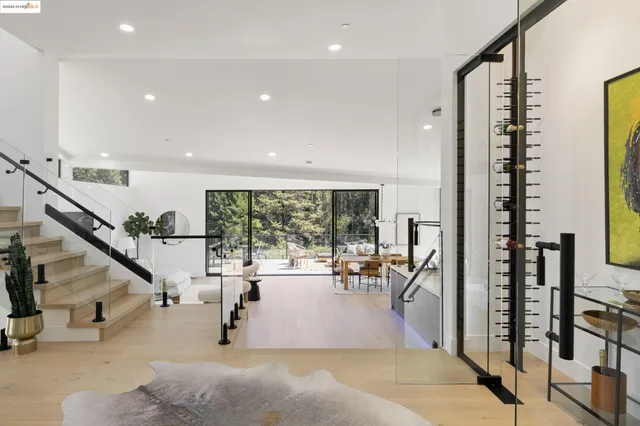 a kitchen with stainless steel appliances a sink a refrigerator and chairs