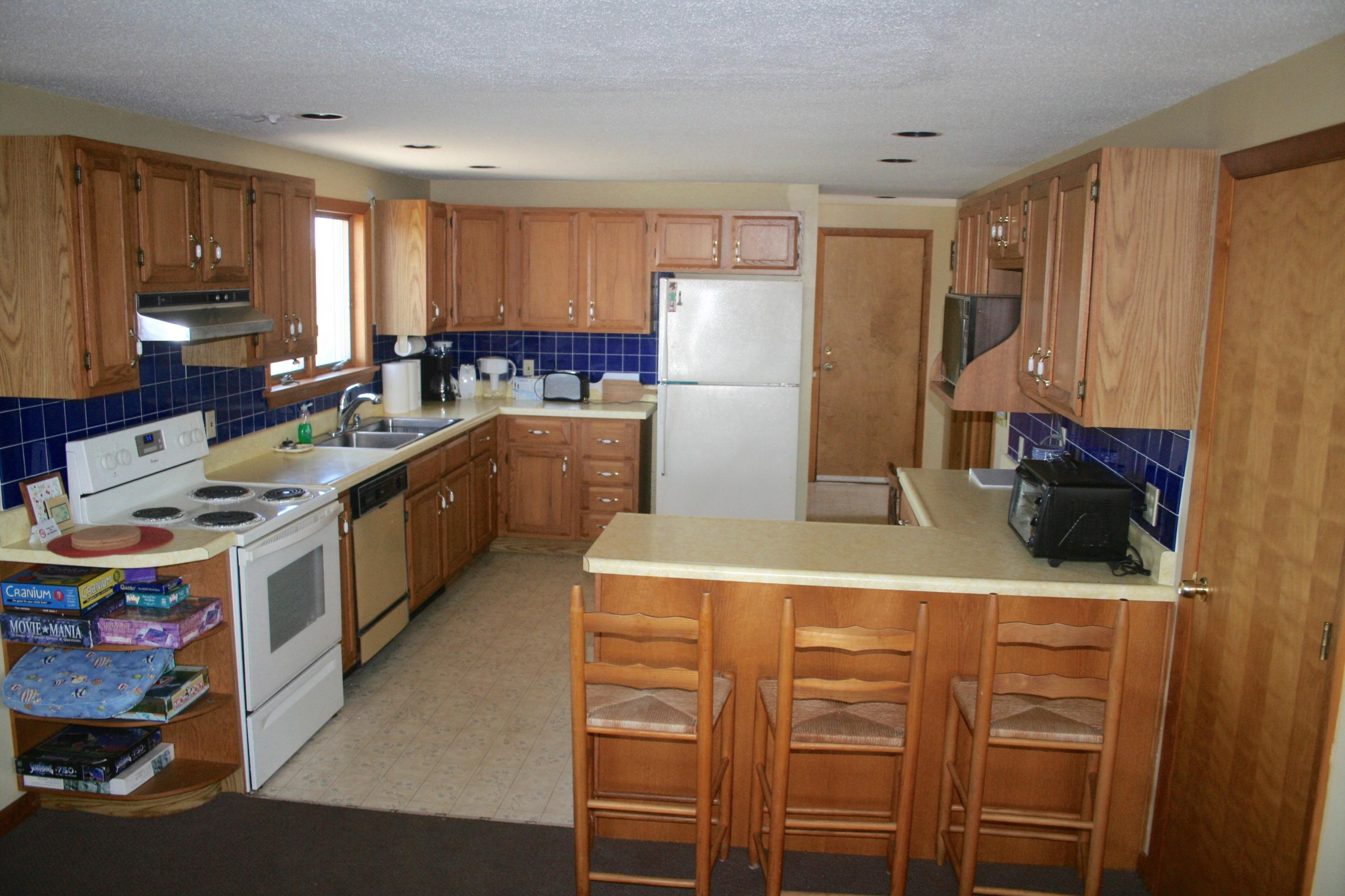 559 Shore Road Truro, MA 02666 - Photo 5 of 9 a kitchen with a refrigerator a stove top oven a sink and cabinets