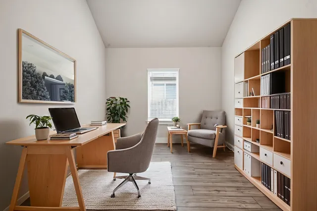 a view of a workspace with furniture and a window
