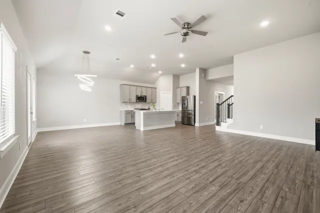 wooden floor in an empty room with a kitchen