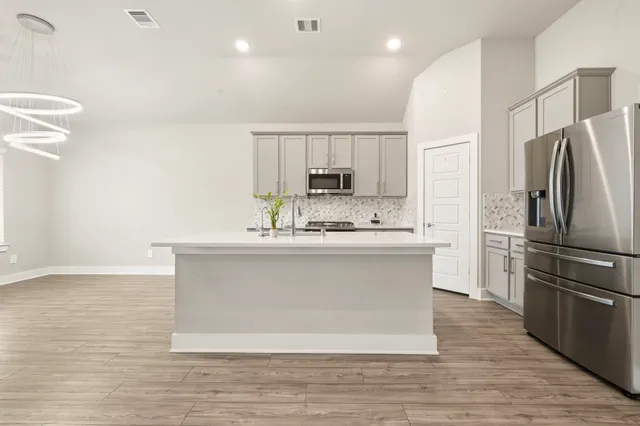 a view with kitchen island a sink wooden floor and a refrigerator
