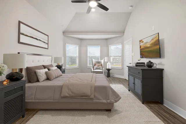 a bedroom with a bed and a flat tv screen on dresser
