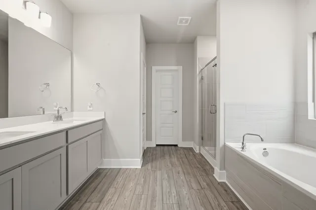 a bathroom with a tub sink and mirror