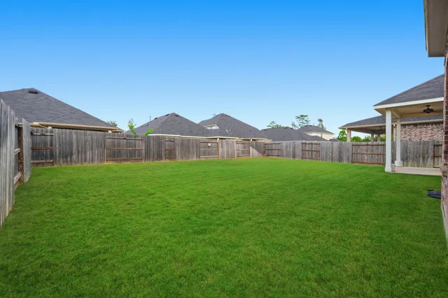 a view of a house with a big yard and large tree