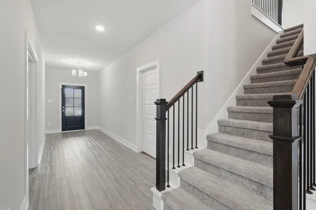 a view of a hallway with wooden floor and entryway