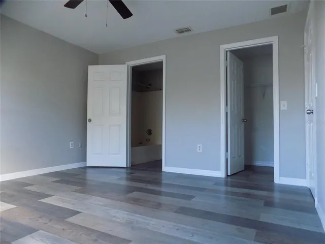 an empty room with wooden floor and closet