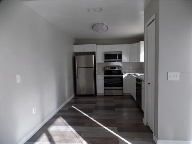 a kitchen with granite countertop a refrigerator and a sink