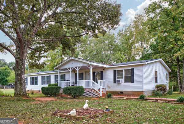 a front view of a house with a yard and trees