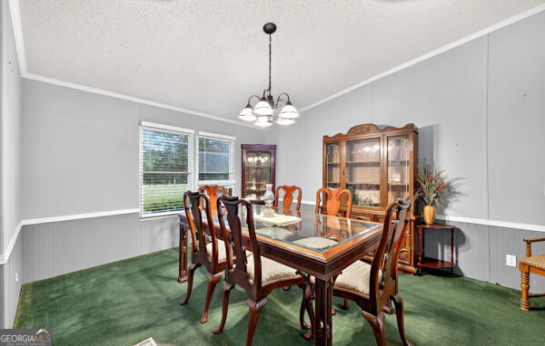 1090 South Hampton Road Hampton, GA 30228 - Photo 7 of 21 a dining room with furniture a chandelier and wooden floor