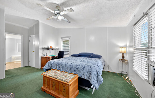 1090 South Hampton Road Hampton, GA 30228 - Photo 8 of 21 a spacious bedroom with a bed and a chandelier