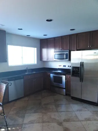 a kitchen with stainless steel appliances kitchen island granite countertop a stove a sink and a microwave
